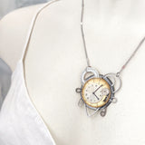 girocollo quadrante oro e bianco e ingranaggi di orologi